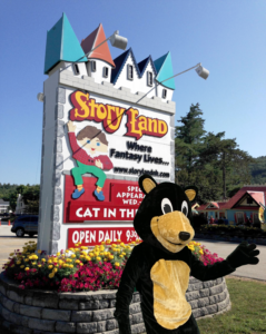 Underhill Mascot in front of the Storyland Sign
